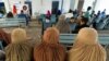 FILE - Afghan women refugees living in Pakistan wait to get registered at an office in Peshawar, Pakistan, Sept. 30, 2021.