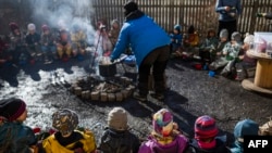 Anak-anak dari sekolah PAUD "I Ur och Skur" di Jarvastaden, Solna, Swedia, makan rebusan sosis untuk makan siang, 1 Maret 2023. (Jonathan NACKSTRAND / AFP)