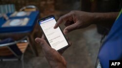Seorang pekerja menunjukkan menu digital di restoran Casa Nossa di lingkungan Lapa di Rio de Janeiro, Brazil, 24 Mei 2023. (MAURO PIMENTEL/AFP)