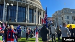 Para pengunjuk rasa berkumpul di halaman Parlemen Selandia Baru, saat mereka berdemonstrasi menentang apa yang mereka anggap sebagai pelanggaran pemerintah terhadap kebebasan, di Wellington, Selandia Baru, 23 Agustus 2022. (Foto: Reuters)