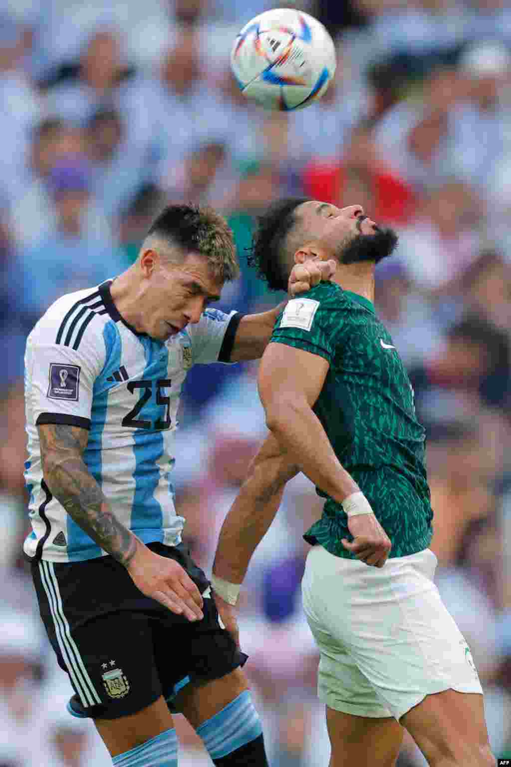 Mobateli to défenseur #25 Lisandro Martinez ya Argentine (G) azali kowelela ndembo na moto na mobateli ya Arabie saoudite #04 Abdukekah Alamri na match ya Mondial Qatar 2022 na stade Lusail, Doha, 22 novembre 2022. (Photo Odd ANDERSEN / AFP