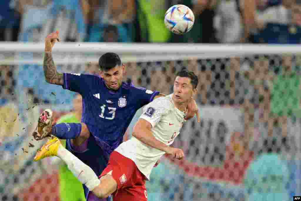 Défenseur ya Argentine #13 Cristian Romero(G) na attaquant ya Pologne #09 Robert Lewandowski bazali kowelela ndembo ya likolo na match ya groupe C ya Mondial Qatar 2022 na stade 974, Doha, 30 novembre 2022. (Photo JUAN MABROMATA / AFP)