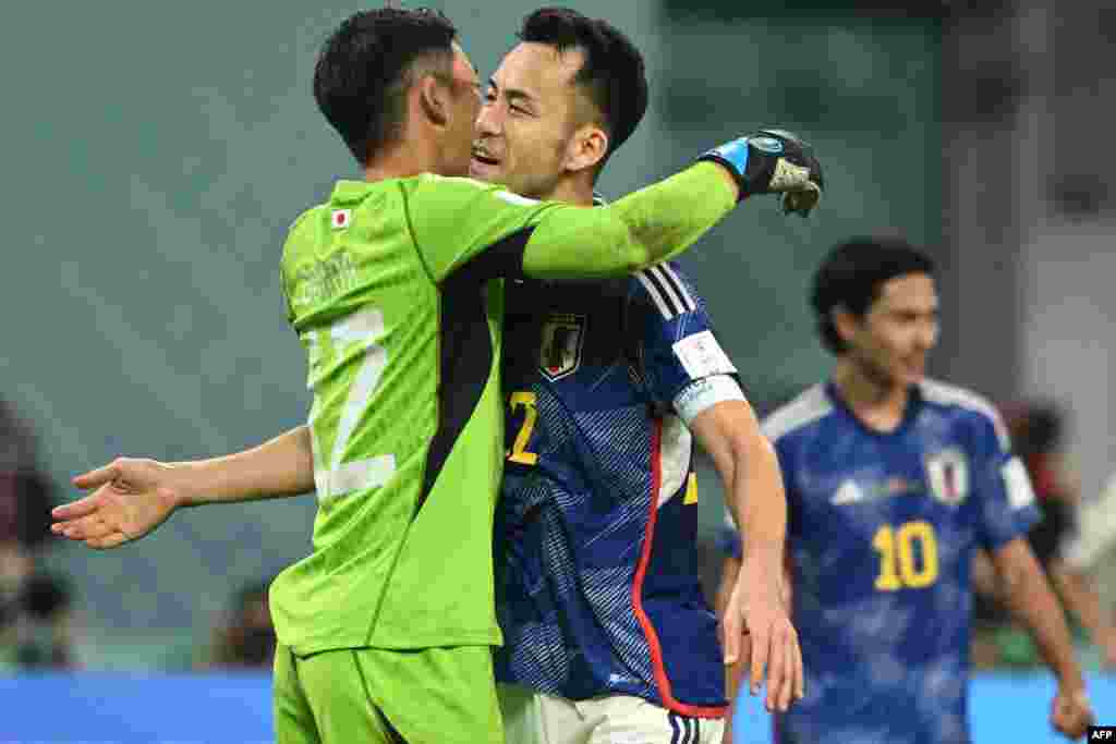 Moyambi ya Japon #12 (G) apesi losako na moninga wa ye mobateli #22 Maya Yoshida nsima na elonga ya ekipi na ye liboso lya Allemagne 2-1 na match ya gorupe E ya Mondial Qatar 2022 na stade Khalifa, Doha, 23 novembre 2022. (Photo INA FASSBENDER/ AFP)