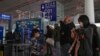 FILE - Passengers wearing face masks line up for a security check to enter a departure gate at Beijing Capital International Airport, in Beijing, China, Dec. 29, 2022.