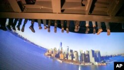 Sejumlah orang menaiki wahana yang dinamakan 'RiseNY' yang terletak di dekat Times Square, New York, pada 1 Maret 2022. Sebuah kajian dari Biro Sensus AS menunjukkan hampir sekitar 3.000 county di Amerika mengalami penurunan populasi pada 2021. (Foto: AP/Ted Shaffrey)