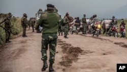 People walk along a road near Kibumba, north of Goma, Democratic Republic of Congo, as they flee fighting between Congolese forces and M23 rebels in North Kivu, May 24, 2022. 