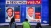 Warga menyaksikan hasil pemilihan presiden Kolombia yang terpampang di sebuah layar elektronik di Medellin, Kolombia, Minggu, 29 Mei 2022. Hasil awal menunjukkan mantan wali kota Bogota Gustavo Petro, 62 tahun, memimpin dengan 40,3% suara. (Foto: Joaquin Sarmiento/AFP)
