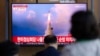 Sejumlah orang di sebuah stasiun kereta di Seoul, Korea Selatan, menonton tanyangan berita yang mengabarkan peluncuran uji coba rudal yang dilakukan oleh Korea Utara pada 25 Mei 2022. (Foto: AP/ Lee Jin-man)