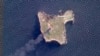 Foto satelit yang diabadikan oleh Planet Labs PBC menunjukkan asap hitam pekat membubung setelah serangan terhadap posisi Rusia di Pulau Ular yang diduga dilancarkan oleh pesawat nirawak Ukraina di Laut Hitam, 6 Mei 2022. (Foto: Planet Labs PBC via AP)