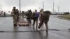 Dalam potongan gambar yang diambil dari video milik Kementerian Pertahanan Rusia pada 19 Mei 2022, para tentara Ukraina, kanan, meninggalkan pabrik baja Azovstal di Mariupol, Ukraina. (Foto: Russian Defense Ministry Press Service via AP)