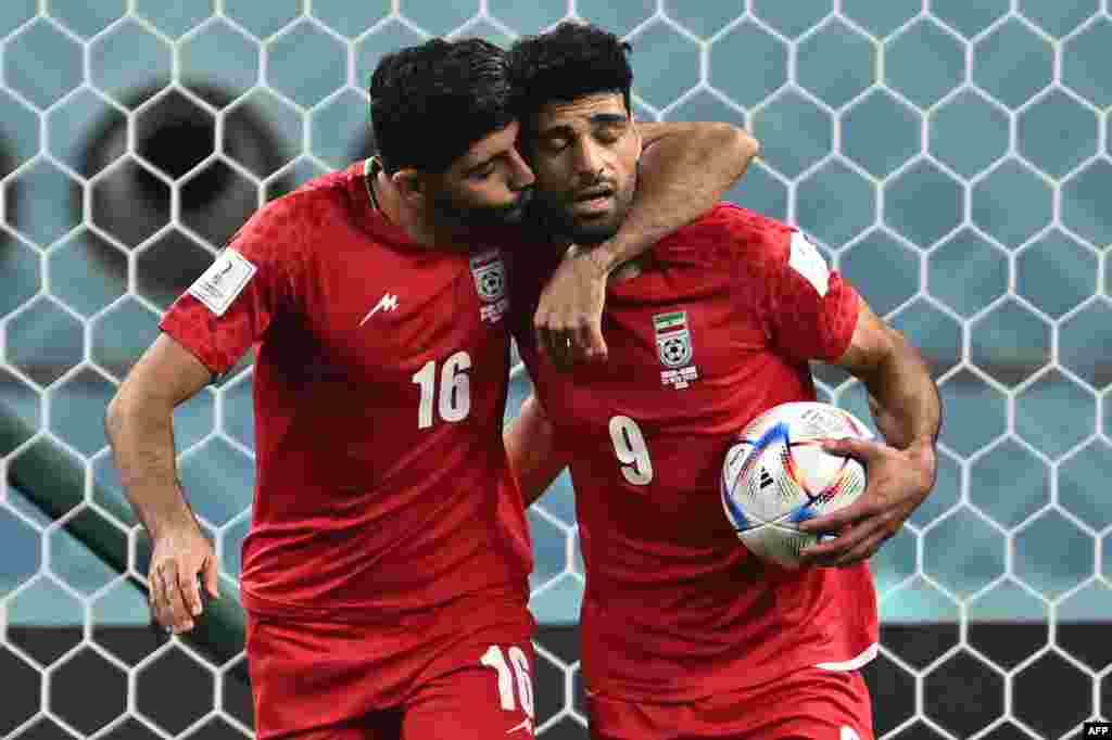 Attaquant ya Iran #09 Mehdi Taremi (D) azali kosepela na moninga wa ye ya ekipi milieu #16 Mehdi Torabi liboso lya Grande-Bretagne na match ya groupe B ya Mondial Qatar 2022, na stade Khalifa, Doha, 21 novembre 2022. (Photo Paul ELLIS / AFP)