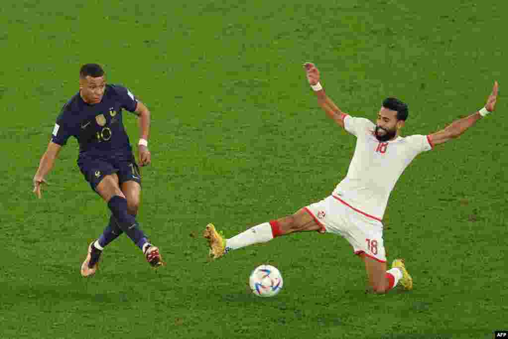 Milieu ya Tunisie #18 Ghailene Chaalali azali komeka kokanga ndembo attaquant ya France #10 Kylian Mbappé abeti na match ya groupe D na Mondial Qatar 2022 na stade Al-Rayyan, Doha, 30 novembre 2022. (Photo Adrian DENNIS / AFP)