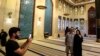 Pasangan asal Kanada Dorinel dan Clara Popa berpose di dalam Masjid Biru atau Blue Mosque, di Doha, pada 29 November 2022, ketika berkunjung ke Qatar untuk menyaksikan Piala Dunia 2022. (Foto: AFP/Mahmud Hams)
