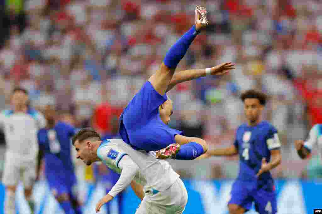 Milieu ya Angeterre #19 Mason Mount na nse ya défenseur ya Etats-Unis #02, bazali kowela ndembo na groupe B ya Mondial Qatar 2022 na stade Al Khor, Doha, 25 novembre 2022. (Photo Odd ANDERSEN / AFP)
