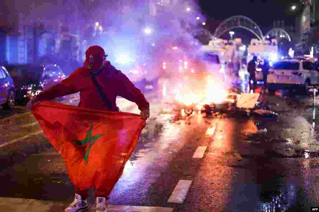 Mokimisi moko na bendele ya Maroc pene na tuku tuku moko etumbami na nzela na Bruxelles (Belgique), nsima na Belgique kopola 0-2 na Maroc, na match ya groupe F ya Mondial Qatar 2022, 28 novembre 2022. (Photo Kenzo TRIBOUILLARD / AFP)