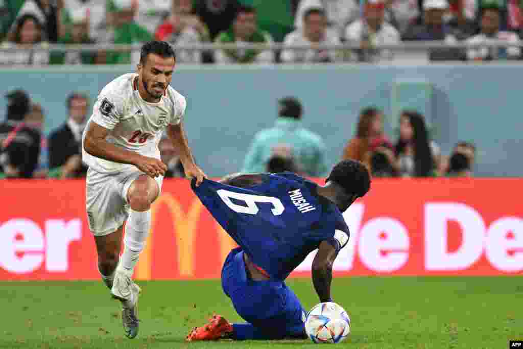 Défenseur ya Iran #25 Abolfazi Jalali abendi milieu ya Etats-Unis #06 Yunus Musah na elamba na match ya groupe B ya Mondial Qatar 2022 na stade Al-Thumama, Doha, 29 novembre 2022. (Photo Patrick T. Fallon / AFP)