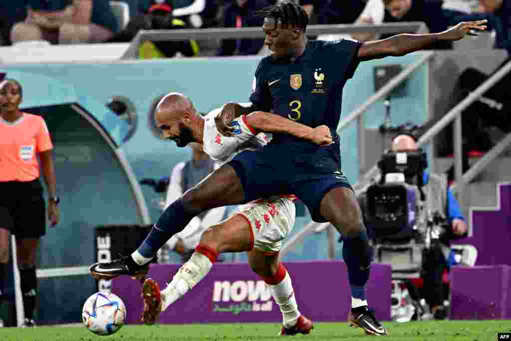 Attaquant ya Tunisie #09 Issam Jebali azali kowelela ndembo na défenseur ya France #03 Axel Disasi na match ya groupe D ya Mondial Qatar 2022 na stade Al-Rayyan, Doham 30 novembre 2022. (Photo Anne-Christine POUJOULAT / AFP)