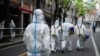 Petugas mengenakan pakaian hazmat saat melakukan penyiraman disinfektan di kawasan perumahan yang terkena lockdown di Shanghai, China, pada 15 April 2022. (Foto: Reuters/Aly Song)