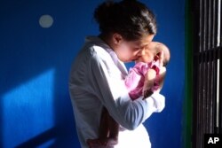 Heather Mack menggendong bayi perempuannya di dalam sel penjara sambil menunggu putusan kasusnya di Bali, 21 April 2015. (Foto: Firdia Lisnawati/AP)