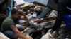 Beberapa pria berusaha mencari jasad yang tertimbun akibat longsor di Morro da Oficina setelah hujan lebat melanda wilayah Petropolis, Brazil, pada 16 Februari 2022. (Foto: Reuters/Ricardo Moraes)