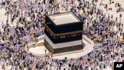 FILE - Muslim pilgrims walk around the Kaaba, the cubic building at the Grand Mosque, during the annual hajj pilgrimage, in Mecca, Saudi Arabia, on July 10, 2022.