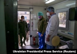 Presiden Ukraina Volodymyr Zelenskyy mengenakan masker memeriksa laboratorium berjalan milik militer. (Foto: via Reuters)