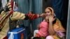 Seorang petugas kesehatan memberikan vaksin polio kepada seorang anak dalam program pemberian vaksin polio dari rumah ke rumah di wilayah padat di Lahore, Pakistan, pada 23 Mei 2022. (Foto: AFP/Arif Ali)