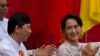 Myanmar opposition leader Aung San Suu Kyi, right, and pro-democracy activist Min Ko Naing clap hands during a public rally in Yangon, Myanmar, Saturday, May 17, 2014. Democracy activists joined Suu Kyi for the first time calling for an amendment to Myanm