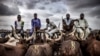 Un groupe de bergers vendant des vaches attendent des clients au marché aux bestiaux de Kara à Lagos, au Nigéria, le 10 avril 2019.