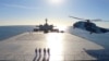 FILE - This image made from a video released Jan. 13, 2021, by the Iranian Army shows a helicopter landing on the Makran logistics vessel during a navy drill. (Iranian Army via AP)