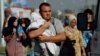 Un hombre carga a un niño mientras palestinos que huyen del norte de Gaza caminan hacia el sur, en medio del conflicto en curso entre Israel y Hamás, en el centro de la Franja, el 9 de noviembre de 2023.