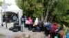A line of asylum seekers who said they were from Haiti wait to enter into Canada from Roxham Road in Champlain, New York, Aug. 7, 2017.