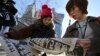 Japanese women react as they read extra newspapers in Tokyo reporting about an online video that purported to show an Islamic State group militant beheading Japanese journalist Kenji Goto, Feb. 1, 2015. 