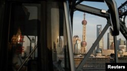 FILE - A bus moves past a bridge with the backdrop of the financial district of Pudong in Shanghai, China, Sept. 27, 2024
