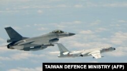在这幅2018年5月11日台湾国防部发送的档案照中，一架中华民国（台湾）空军F-16战斗机在飞行中靠近一架中国空军H-6K轰炸机。