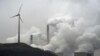 FILE - In this file photo dated Monday, Dec. 1, 2014, a wind turbine overlooks the coal-fired power station in Gelsenkirchen, Germany. 
