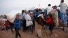 Newly arrived Syrian Kurdish refugees carry their belongings after crossing into Turkey near the southeastern town of Suruc in Sanliurfa province, Sept. 22, 2014. 