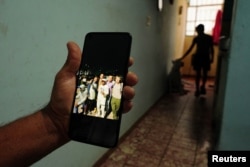 Un familiar muestra una foto de Dannys Castillo, con otros cubanos en Rusia, según el testimonio de su familia, durante una entrevista con Reuters en su casa en Alamar, un suburbio del este de La Habana, Cuba, el 8 de septiembre de 2023.