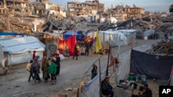 فلسطینی غزہ شہر میں جبالیہ کیمپ کی ایک سڑک پر، اس علاقے کو اسرائیل کی فضائی اور زمینی حملوں سے بھاری نقصان پہنچا ہے۔ فوٹو اے پی

