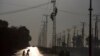 اسلام آباد کے نواح میں ایک الیکٹریسٹی کمپنی کے ملازمین بجلی کے کھمبوں پر چڑھے برقی رو بحال کرنے کی کوشش کر رہے ہیں۔ فوٹو اے پی 