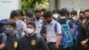 Para siswa di Bengaluru, India, menggunakan masker sebagai langkah pencegahan penularan COVID-19 saat mereka menunggu bis sekolah yang akan datang menjemput pada 30 November 2021. (Foto: AP/Aijaz Rahi)