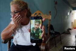 Marilin Vinent muestra una foto de su hijo Dannys Castillo vestido con uniforme militar, con un mensaje del 22 de agosto que dice en español: "Ya estoy enredado". En Alamar, La Habana, Cuba, el 6 de septiembre de 2023.