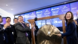 Jenny Qian Zhiya, directora ejecutiva de Luckin Coffee, y Charles Zhengyao Lu, presidente no ejecutivo de la empresa tocan un gong ceremonial para celebrar la entrada de las acciones de la empresa al mercado de valores. Nueva York, 6 de abril de 2020.