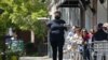 Seorang anggota staf mengantarkan makanan untuk pengunjung yang duduk di luar ruangan di sepanjang trotoar restoran Mediterranean Deli di Chapel Hill, North Carolina, 16 April 2021. (AP Photo/Gerry Broome)