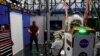 El ingeniero de software de la NASA, Ian Chase, controla el robot humanoide Valkyrie con un casco de realidad virtual y controladores en el Centro Espacial Johnson en Houston.