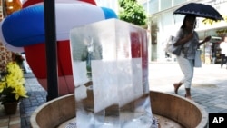 Un bloc de glace est placé dans une rue piétonne pour refroidir l'endroit à Tokyo le vendredi 20 juillet 2018.