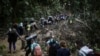 Sejumlah migran tampak berjalan melewati area Celah Darien dari Kolombia menuju Panama untuk mencapai AS, pada 9 Mei 2023. (Foto: AP/Ivan Valencia)