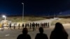 FILE - Migrants line up along the border walls separating Tijuana, Mexico, and San Diego, May 7, 2024. Arrests for illegally crossing the border from Mexico plunged 29% in June to the lowest month of Joe Biden's presidency, according to figures released July 15, 2024, 