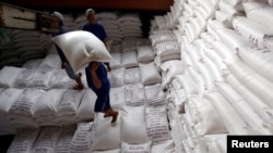 Para pria memuat karung beras ke kapal untuk diekspor di pabrik pengolahan beras di delta Mekong selatan Vietnam, Vietnam 6 Juli 2017. (Foto: REUTERS/Kham)