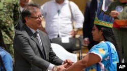 Presiden Kolombia Gustavo Petro menjabat tangan pemimpin masyarakat adat yang berpartisipasi dalam pencarian empat orang anak yang hilang di hutan Amazon, dalam sebauah acara di Bogota, pada 26 Juni 2023. (Foto: AP/Fernando Vergara) 